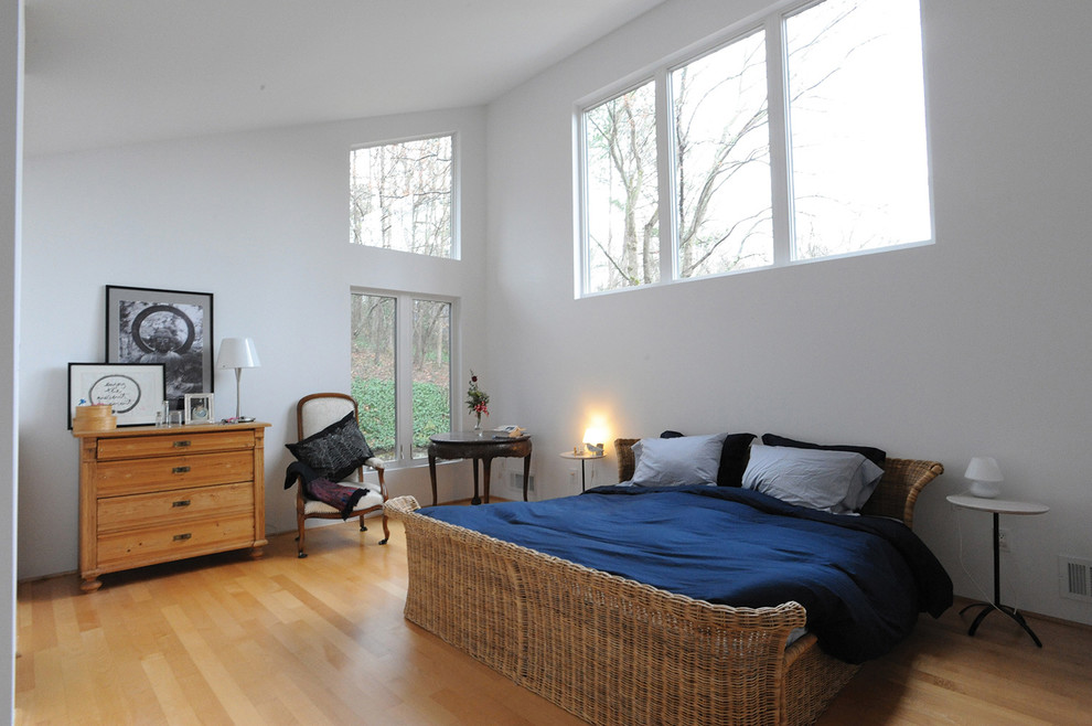 Immagine di una camera degli ospiti minimal di medie dimensioni con pareti bianche e parquet chiaro