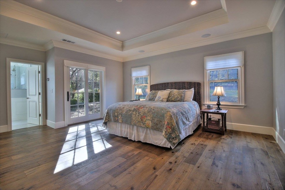 Foto de dormitorio principal tradicional grande con paredes grises y suelo de madera en tonos medios