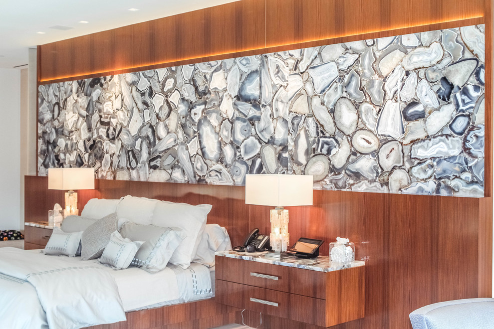 Imagen de dormitorio principal minimalista grande con suelo blanco, paredes beige, suelo de madera clara, chimenea lineal y marco de chimenea de piedra