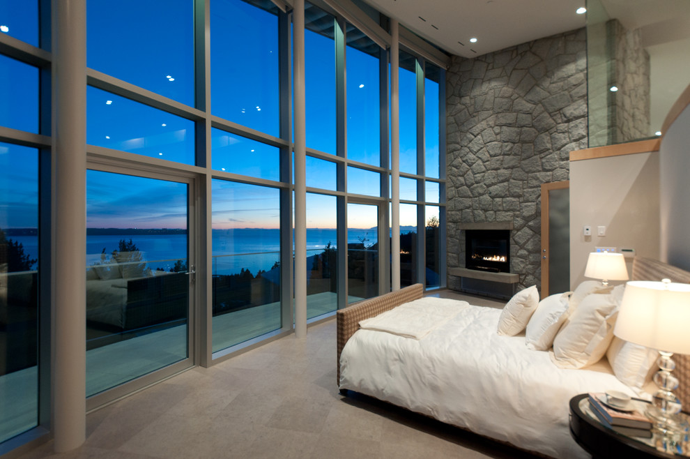 На фото: спальня в современном стиле с бежевыми стенами, стандартным камином и фасадом камина из камня с