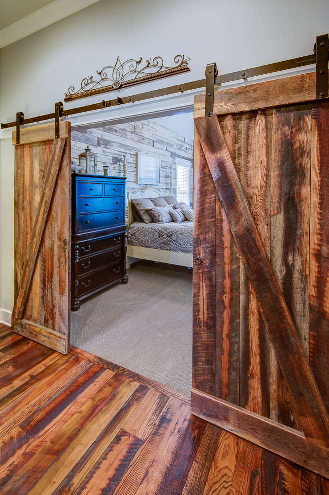 Modelo de habitación de invitados tradicional renovada grande sin chimenea con paredes grises, suelo de madera clara y suelo marrón