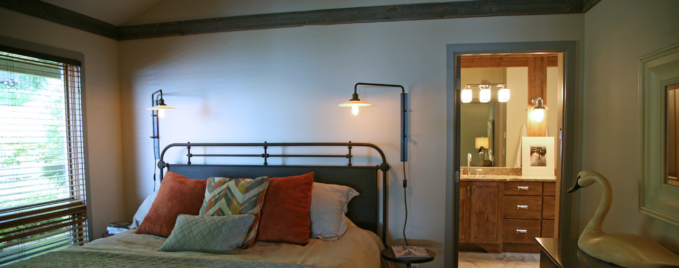 Esempio di una camera matrimoniale industriale con pareti beige e parquet chiaro