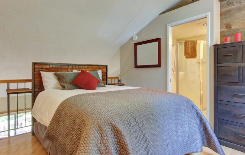 Ejemplo de dormitorio tipo loft rural pequeño con paredes marrones, suelo de madera clara y suelo beige