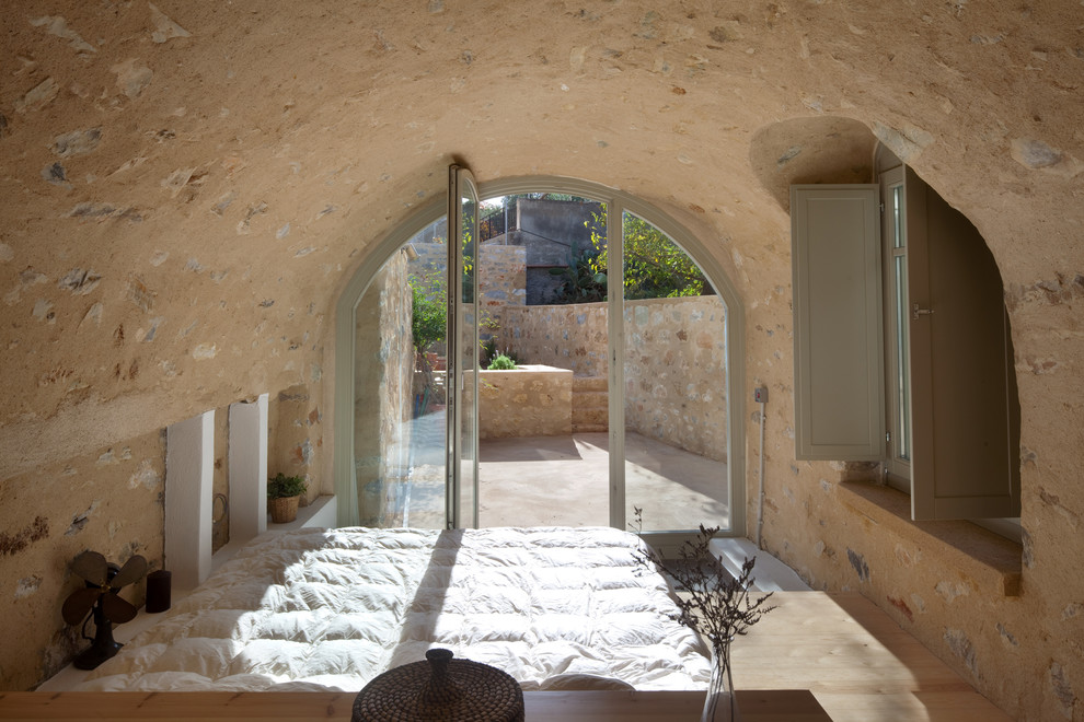 Mediterranes Schlafzimmer mit hellem Holzboden