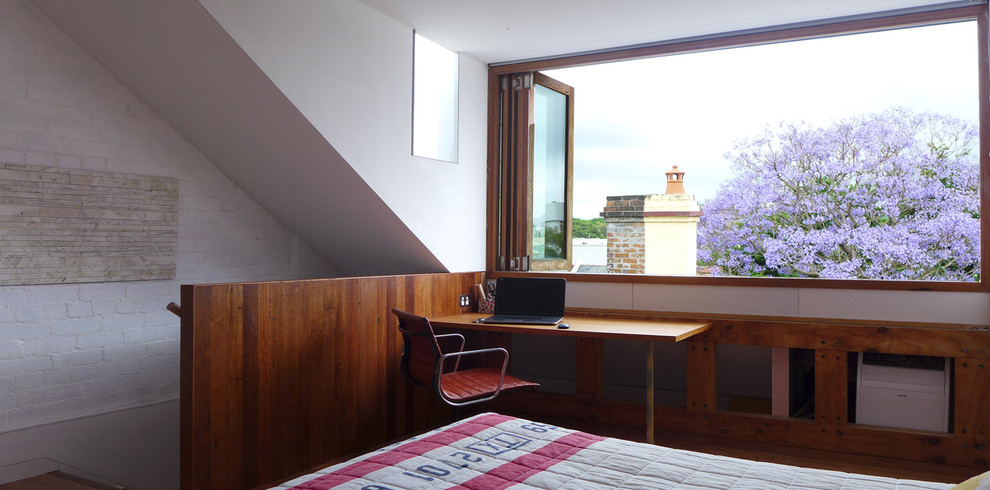 シドニーにある中くらいなコンテンポラリースタイルのおしゃれな主寝室 (コンクリートの床、白い壁、茶色い床)