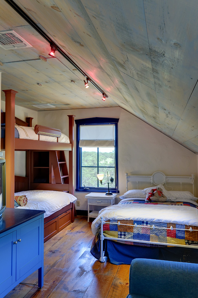 Mittelgroßes Uriges Schlafzimmer im Loft-Style mit beiger Wandfarbe und braunem Holzboden in Austin