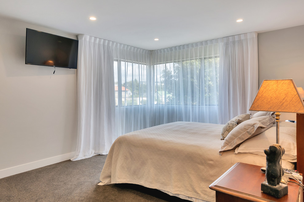 Imagen de dormitorio principal actual de tamaño medio con paredes blancas, moqueta y suelo gris