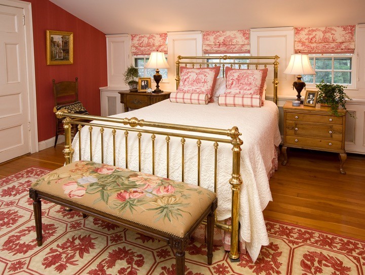 Réalisation d'une chambre victorienne de taille moyenne avec un mur rouge, un sol en bois brun et aucune cheminée.