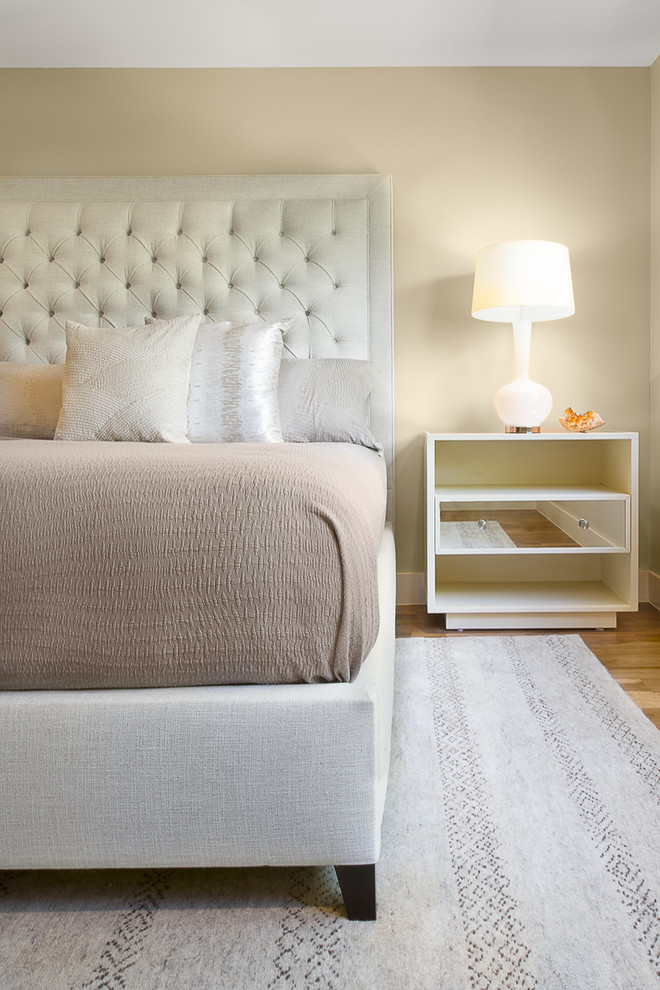 Modelo de habitación de invitados actual con paredes beige y suelo de madera clara