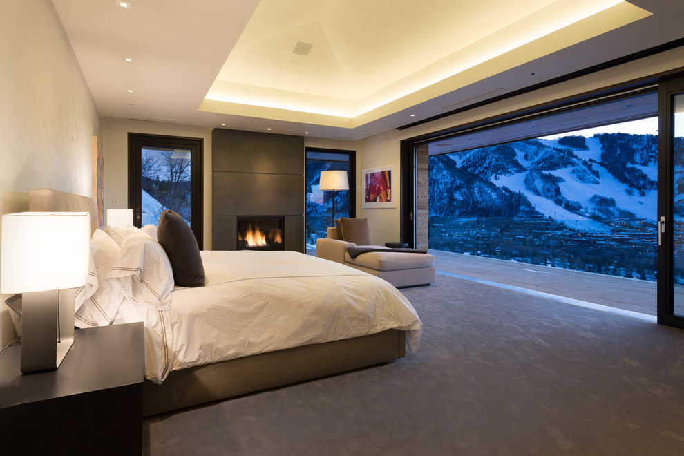 Стильный дизайн: хозяйская спальня в современном стиле с фасадом камина из камня, бежевыми стенами, ковровым покрытием и стандартным камином - последний тренд