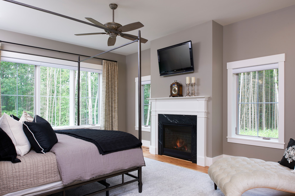 Medium sized classic master bedroom in Detroit with beige walls, medium hardwood flooring, a standard fireplace, a stone fireplace surround and beige floors.