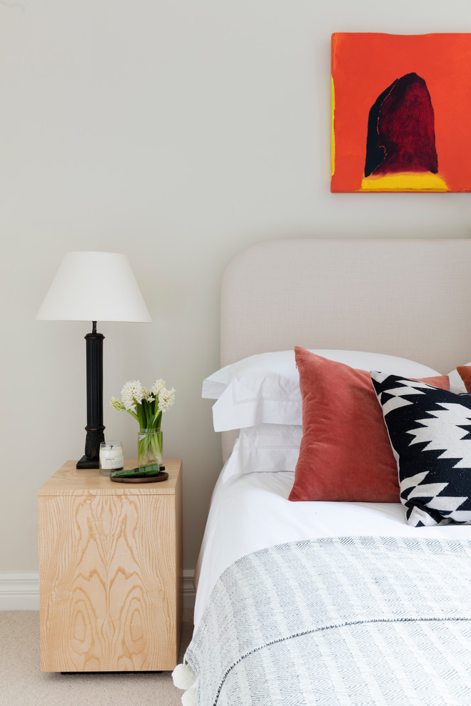 This is an example of a medium sized scandinavian guest bedroom in London with beige walls and carpet.