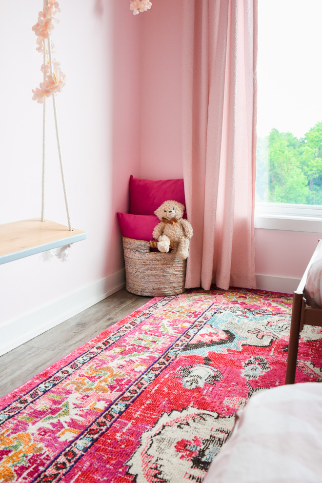На фото: маленькая гостевая спальня (комната для гостей) в современном стиле с розовыми стенами, полом из винила, коричневым полом и панелями на части стены для на участке и в саду с