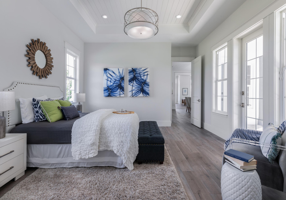 Large coastal master bedroom in Tampa with grey walls, light hardwood flooring and a timber clad ceiling.