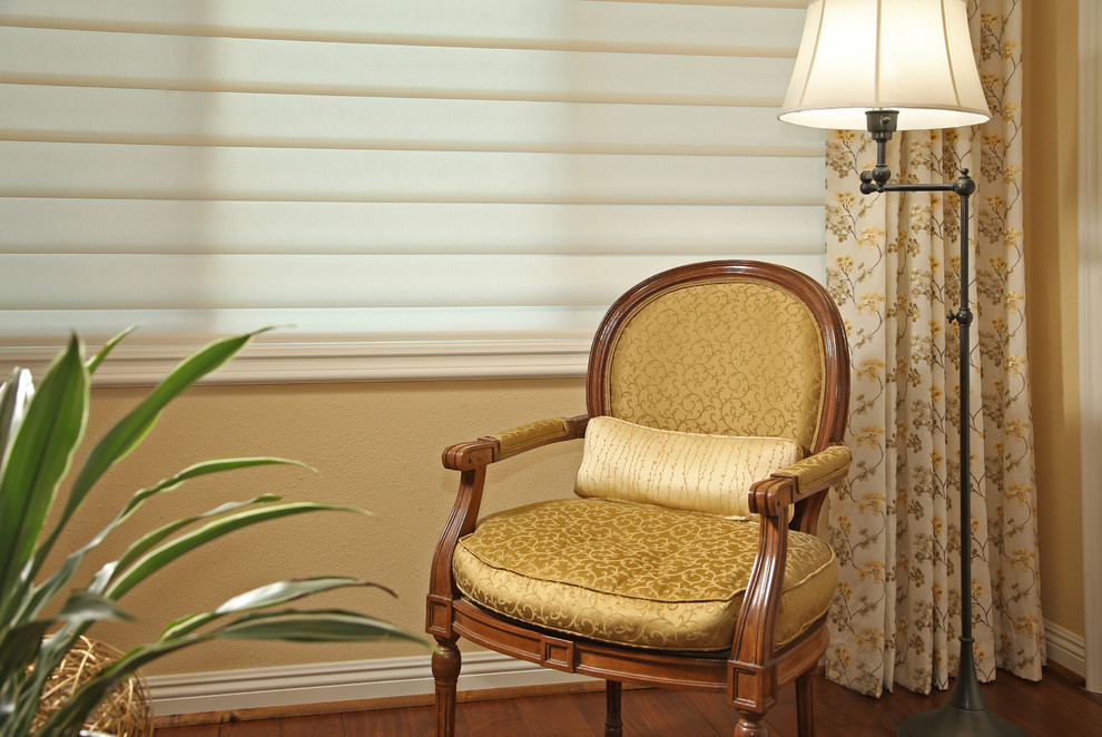 Ejemplo de dormitorio principal clásico de tamaño medio sin chimenea con paredes amarillas, suelo de madera en tonos medios y suelo marrón