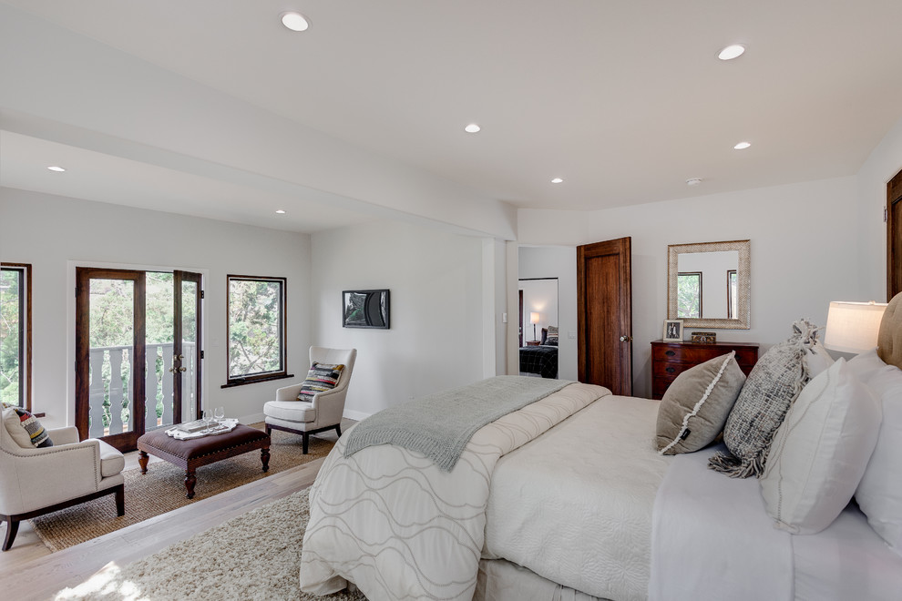 Large classic master bedroom in Los Angeles with light hardwood flooring, no fireplace, white walls and brown floors.