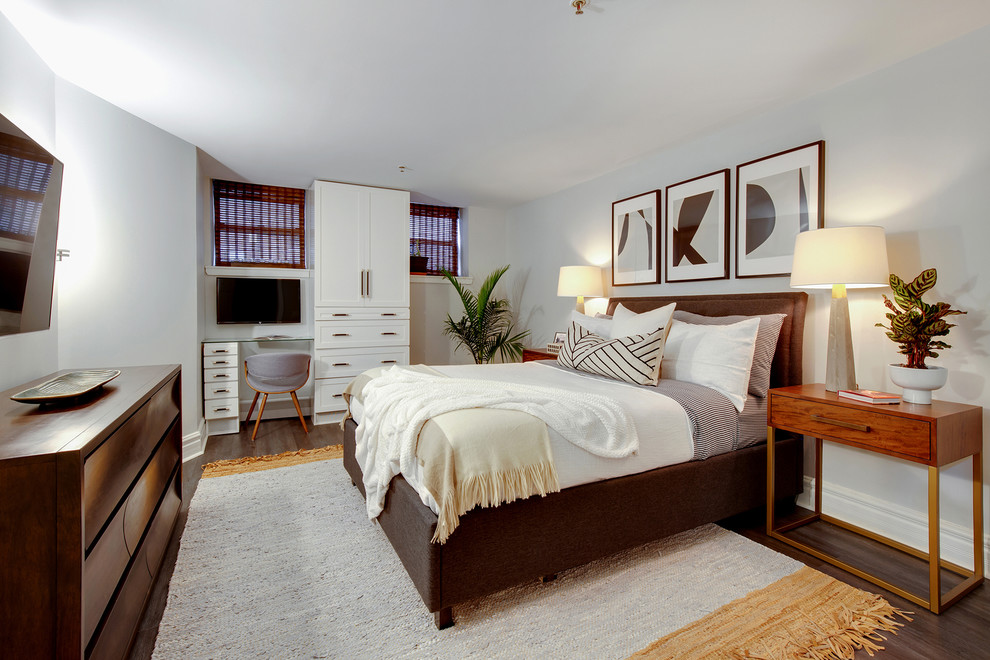 Foto de dormitorio principal tradicional renovado pequeño sin chimenea con paredes grises, suelo laminado y suelo marrón