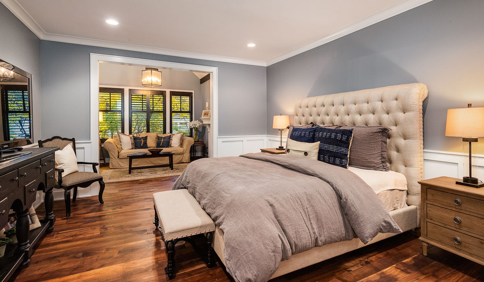Diseño de dormitorio principal de estilo americano de tamaño medio sin chimenea con paredes grises, suelo de madera en tonos medios y suelo marrón