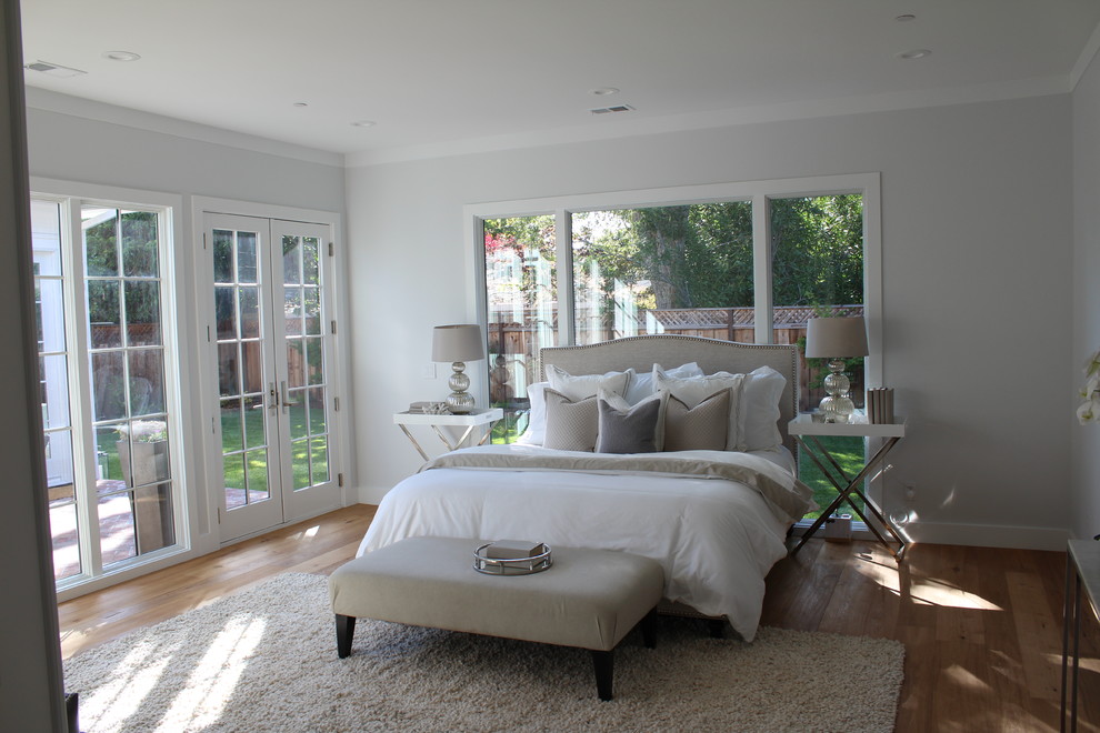 Diseño de dormitorio principal clásico grande con paredes grises, suelo de madera clara y suelo marrón