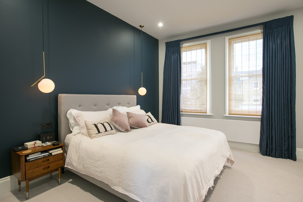 Design ideas for a medium sized contemporary master bedroom in London with blue walls, carpet and beige floors.