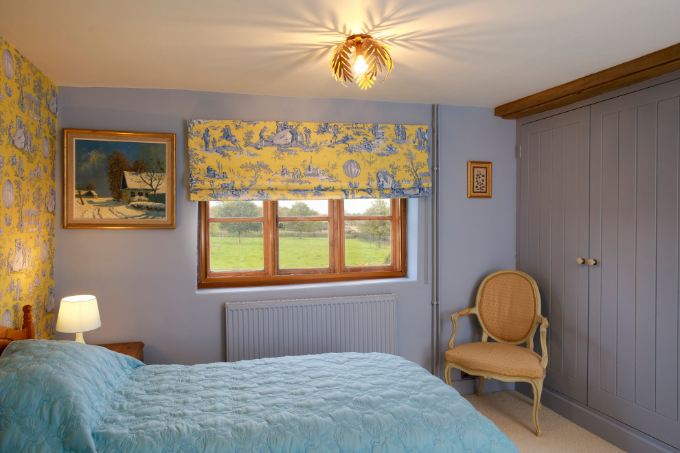 Lantlig inredning av ett sovrum, med blå väggar, heltäckningsmatta och beiget golv