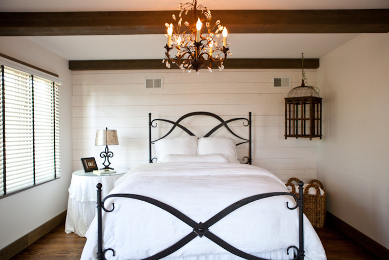 Modelo de habitación de invitados romántica pequeña con paredes amarillas, suelo de madera en tonos medios y suelo marrón