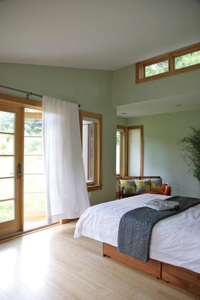 Contemporary bedroom in DC Metro with green walls and light hardwood flooring.