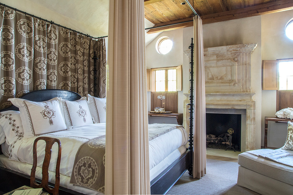 ボルチモアにある地中海スタイルのおしゃれな寝室 (白い壁、淡色無垢フローリング、標準型暖炉、ベージュの床) のレイアウト