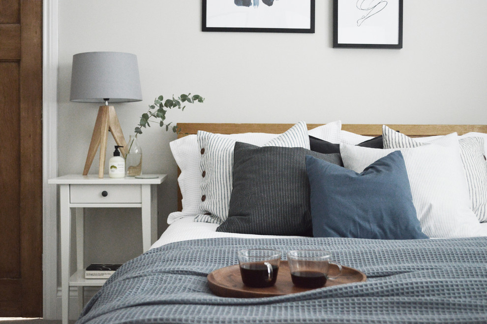 Foto på ett litet minimalistiskt gästrum, med grå väggar, heltäckningsmatta och grått golv