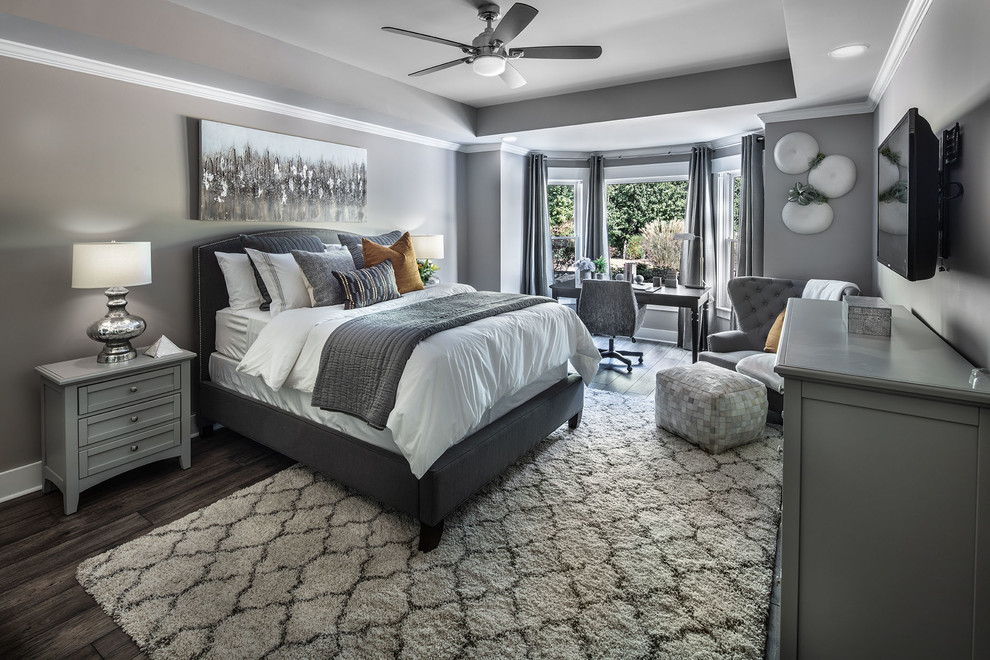 Imagen de habitación de invitados actual de tamaño medio con paredes grises, suelo laminado y suelo marrón