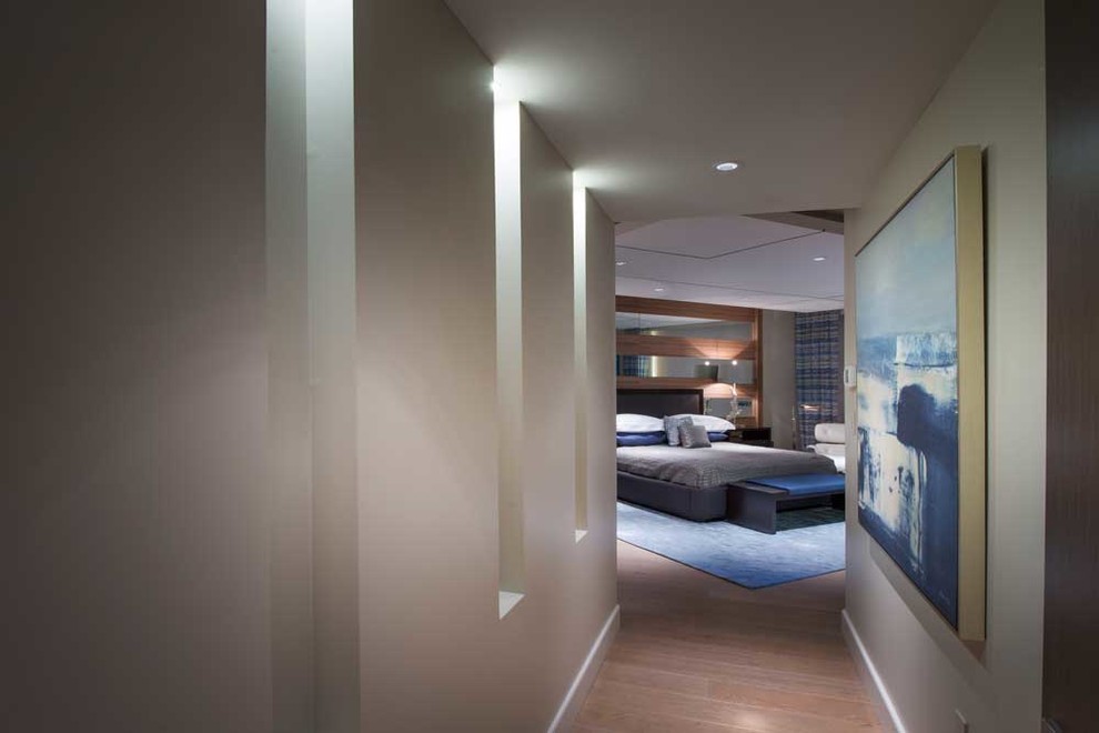 Example of a mid-sized trendy master medium tone wood floor bedroom design in Miami with beige walls and no fireplace