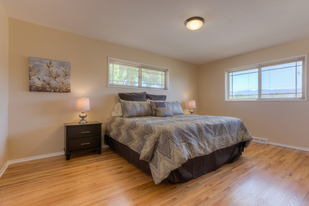 Large elegant master light wood floor bedroom photo in Albuquerque with beige walls and no fireplace