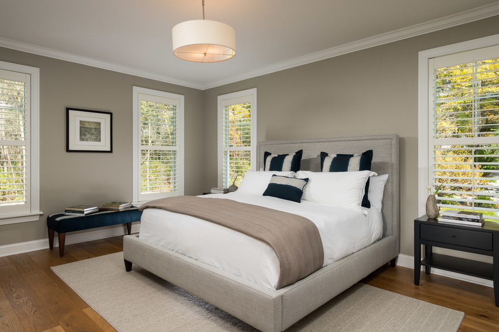 Photo of a traditional grey and brown bedroom in Boston with beige walls, medium hardwood flooring and brown floors.