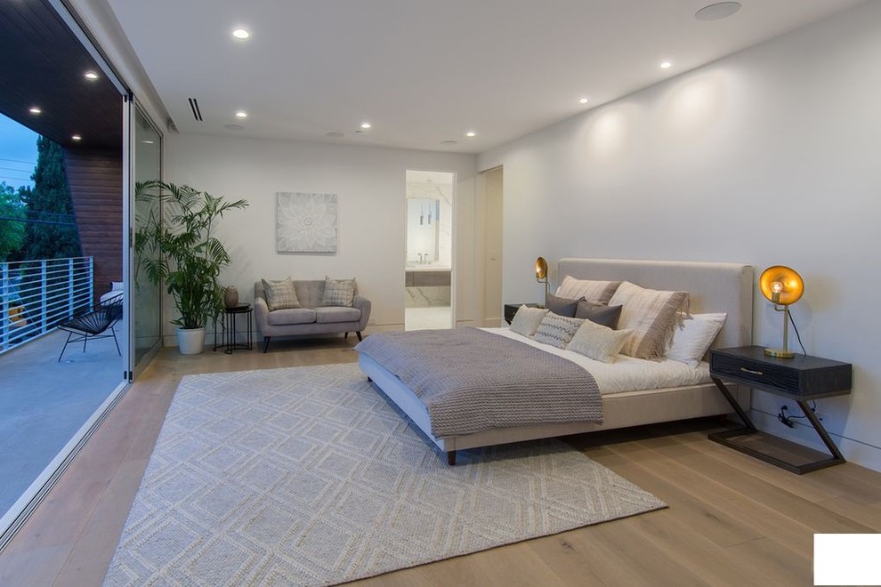 Idée de décoration pour une grande chambre parentale design avec un mur blanc, parquet en bambou et un sol beige.