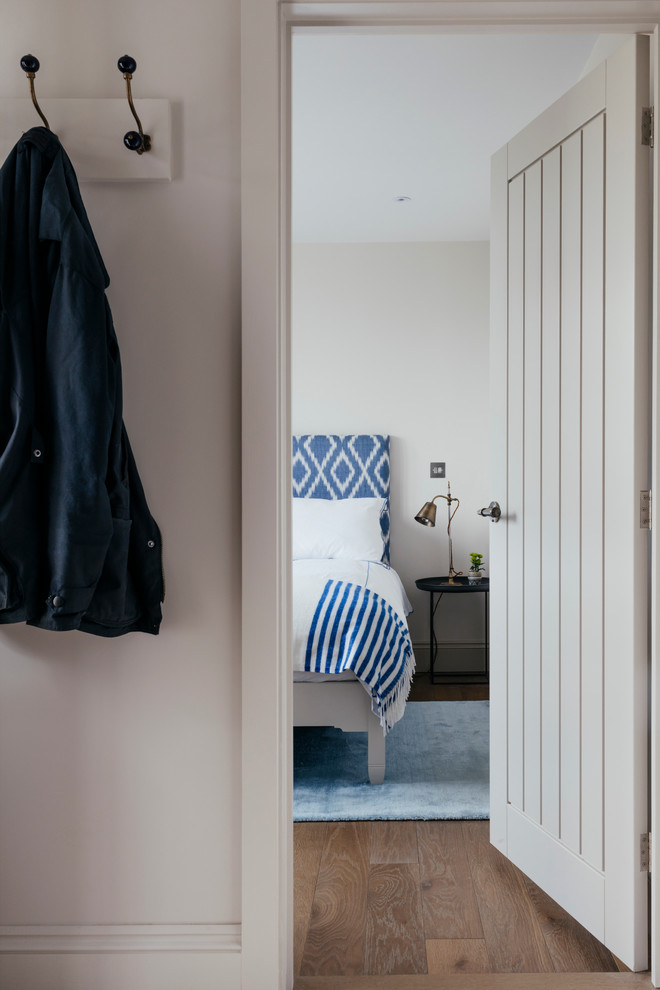 Idee per una camera degli ospiti stile marinaro di medie dimensioni con pareti bianche, pavimento in legno massello medio e pavimento marrone