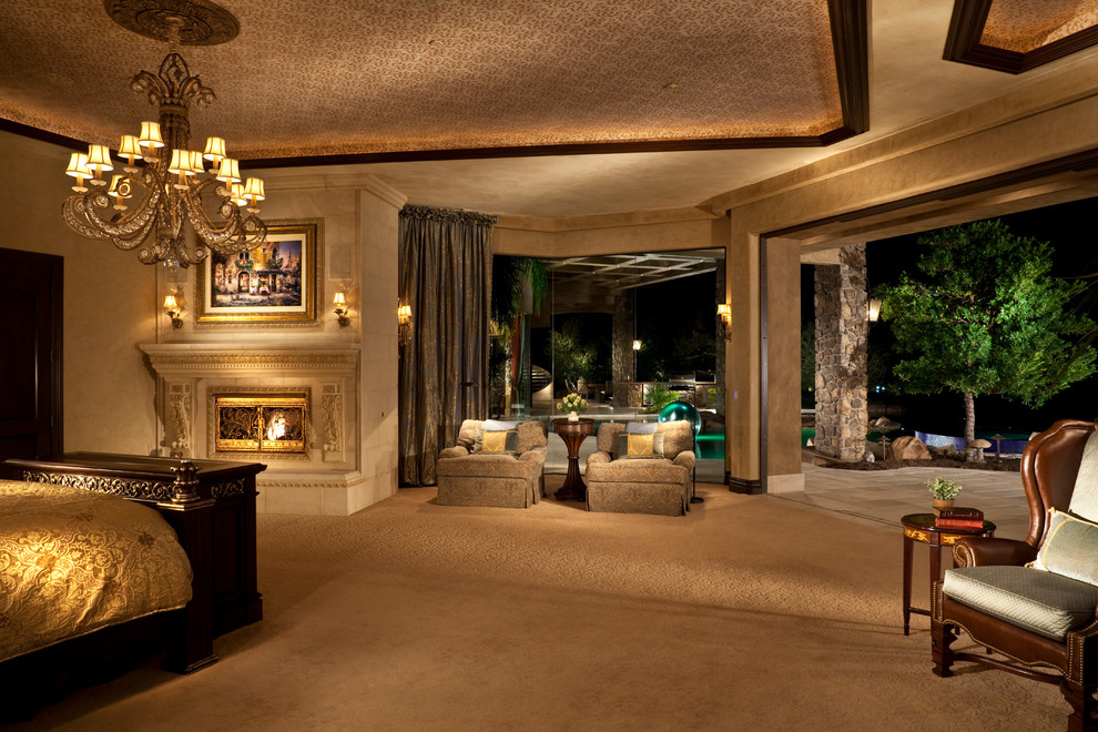 ラスベガスにある広いトラディショナルスタイルのおしゃれな主寝室 (ベージュの壁、カーペット敷き、標準型暖炉、石材の暖炉まわり)