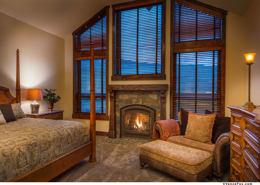 他の地域にある広いラスティックスタイルのおしゃれな客用寝室 (ベージュの壁、カーペット敷き、標準型暖炉、石材の暖炉まわり) のレイアウト