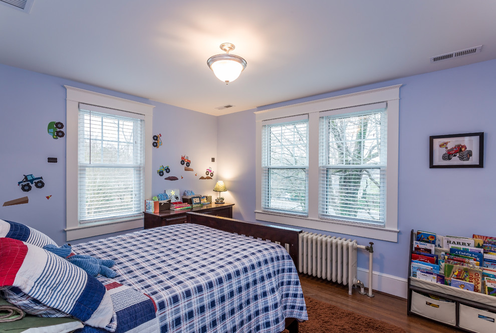 Cette photo montre une petite chambre craftsman avec un mur bleu et un sol en bois brun.