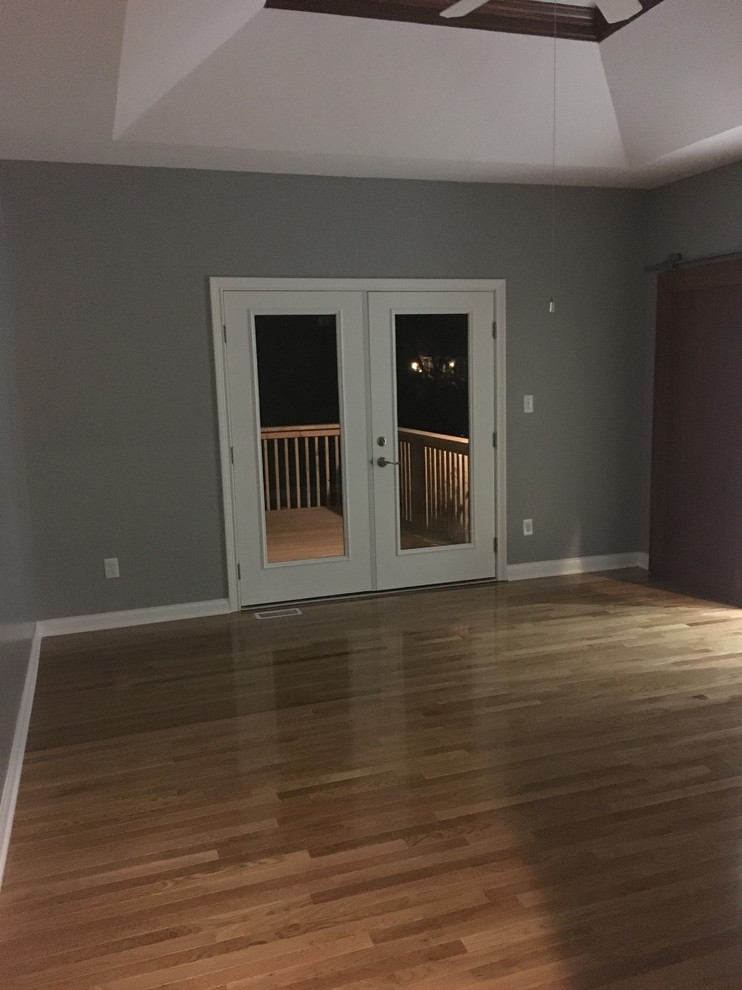 Mittelgroßes Country Hauptschlafzimmer mit grauer Wandfarbe, braunem Holzboden und braunem Boden in Indianapolis