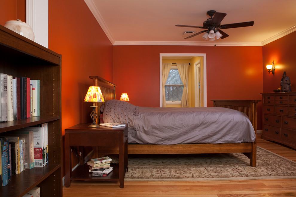 Exemple d'une chambre parentale chic de taille moyenne avec un mur rouge et un sol en bois brun.