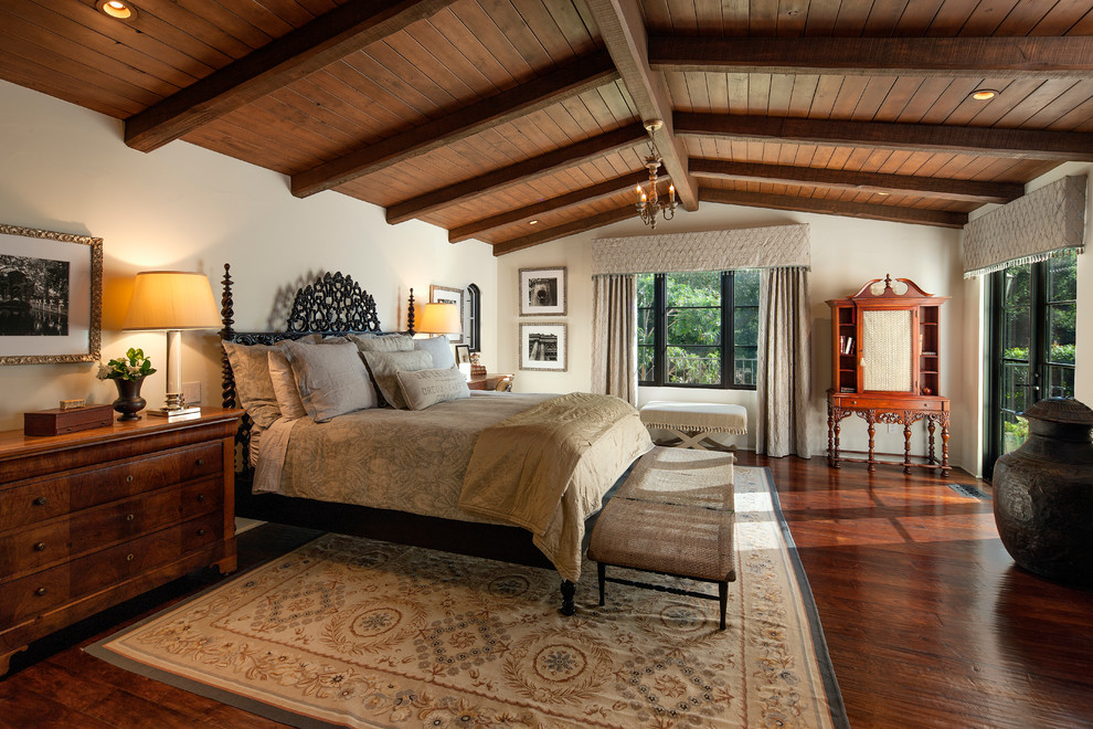 Mediterranes Schlafzimmer mit beiger Wandfarbe und dunklem Holzboden in Santa Barbara
