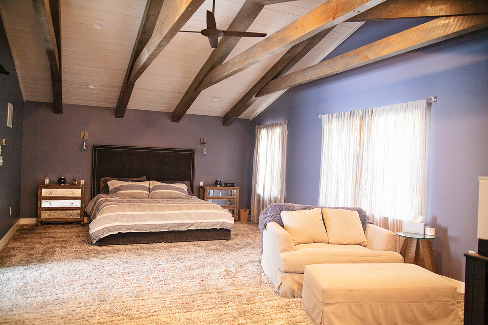 Cette photo montre une grande chambre moderne avec un mur violet, une cheminée double-face, un manteau de cheminée en bois et un sol gris.