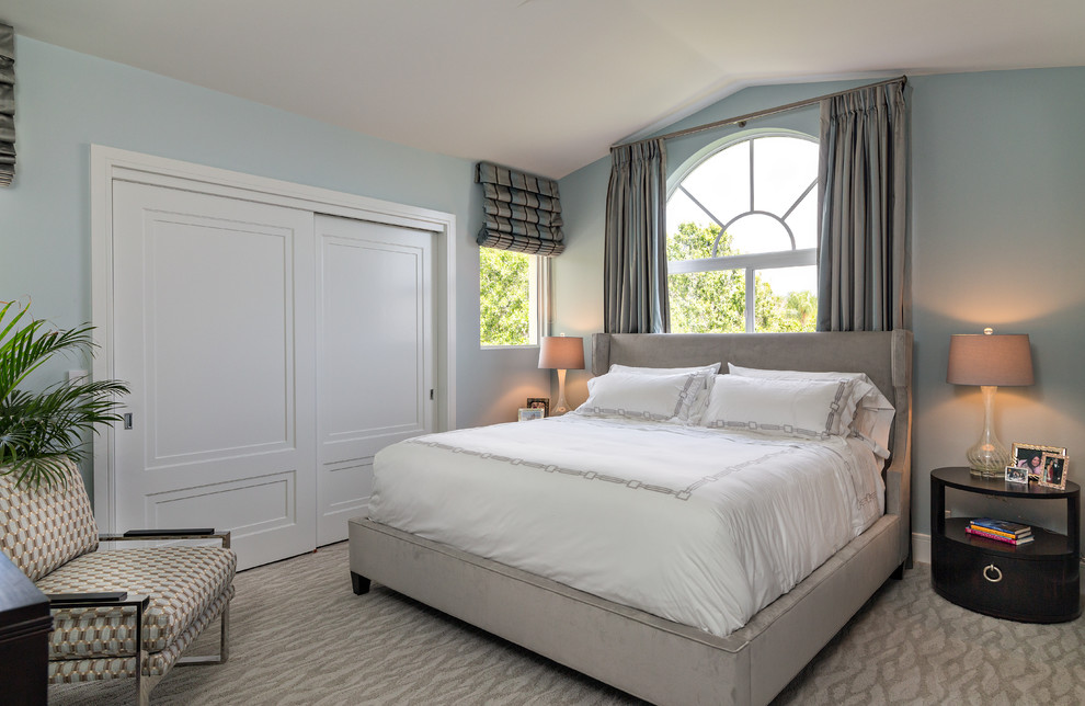 Modelo de dormitorio contemporáneo con paredes azules y moqueta