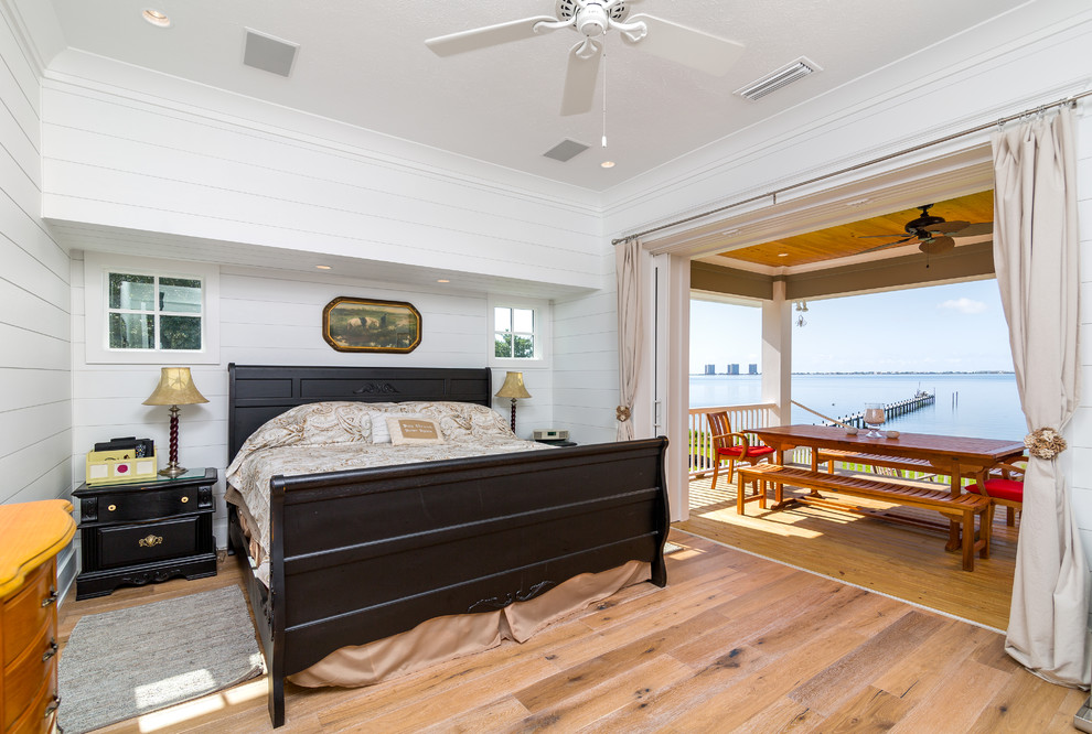 Ejemplo de dormitorio tipo loft marinero de tamaño medio con paredes blancas y suelo de madera en tonos medios