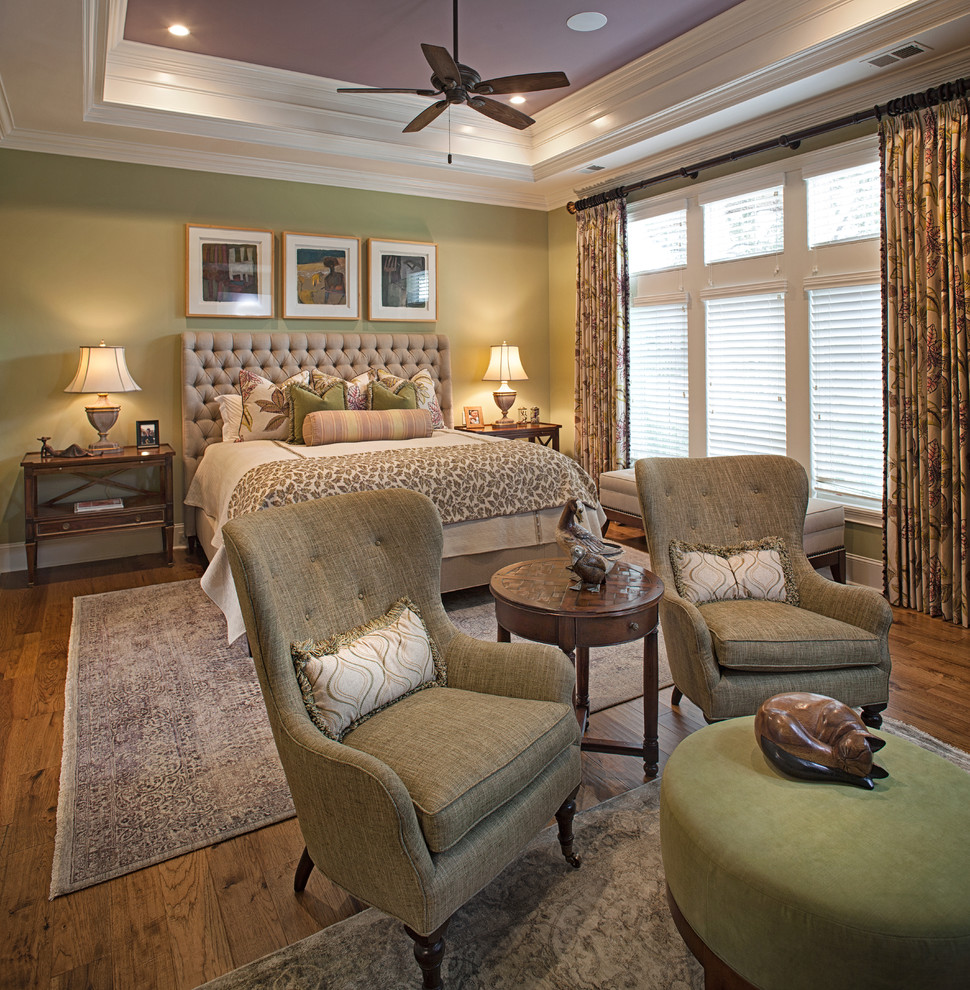 Klassisches Schlafzimmer mit grüner Wandfarbe, dunklem Holzboden und braunem Boden in Sonstige