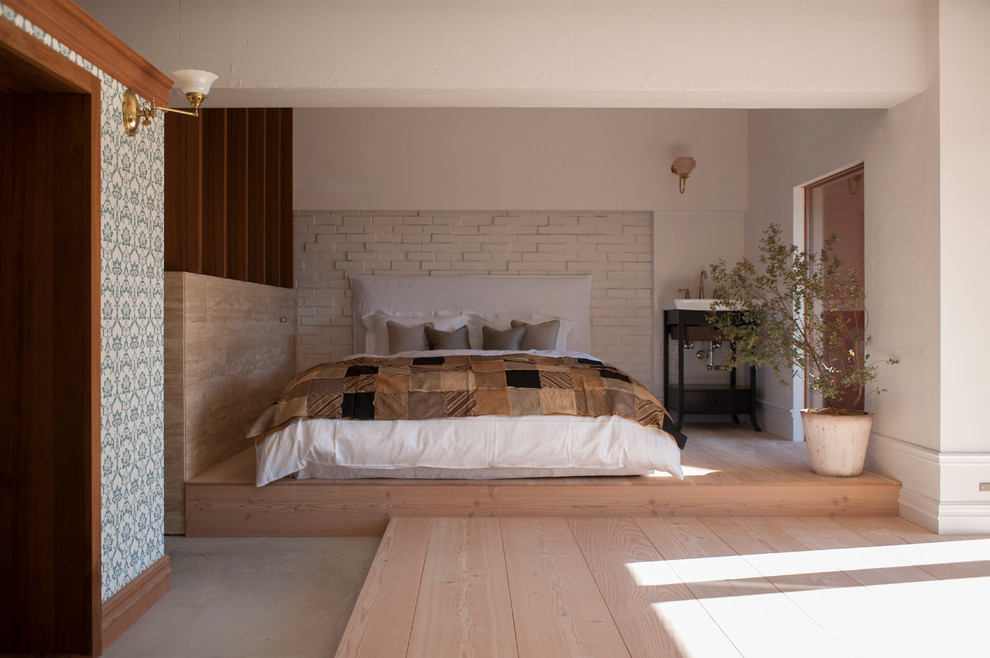 Ejemplo de dormitorio principal contemporáneo con suelo de madera clara y paredes blancas