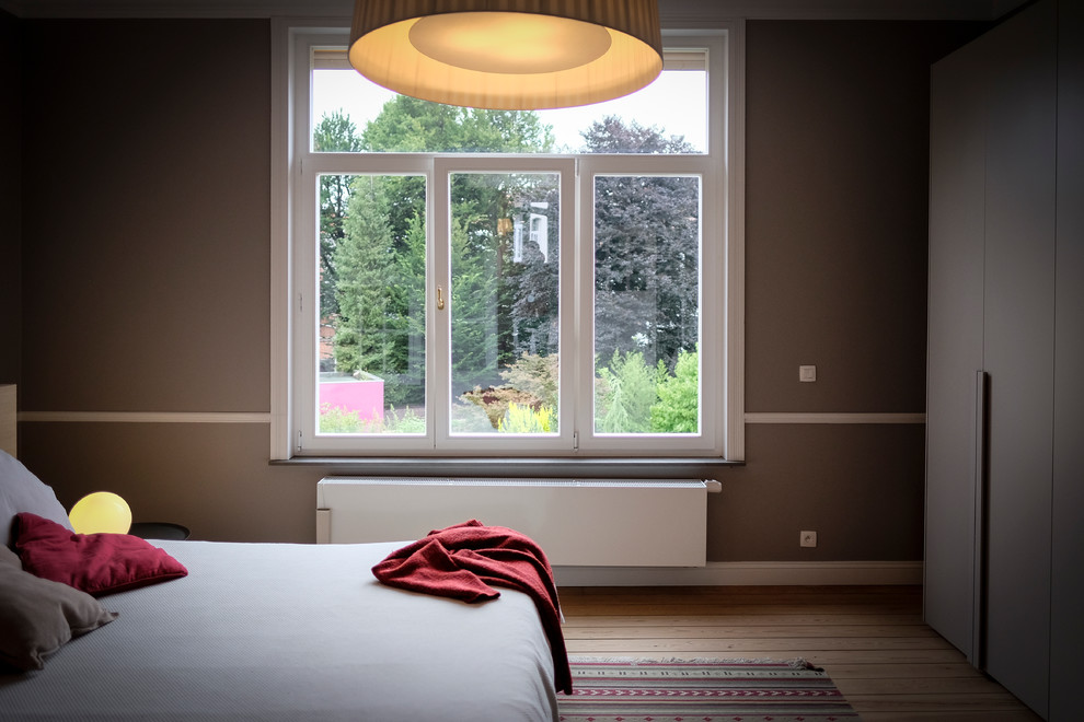 Foto de dormitorio principal actual de tamaño medio con paredes grises y suelo de madera clara