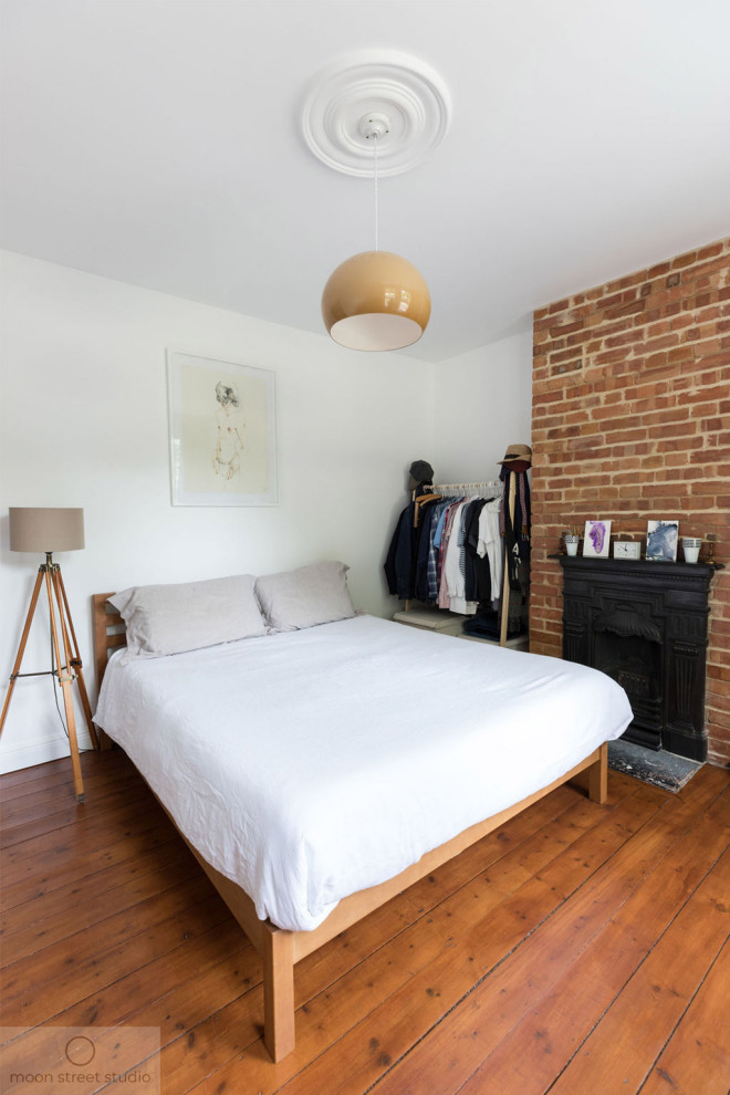 ロンドンにある中くらいなコンテンポラリースタイルのおしゃれな主寝室 (白い壁、無垢フローリング、標準型暖炉、金属の暖炉まわり、茶色い床) のインテリア