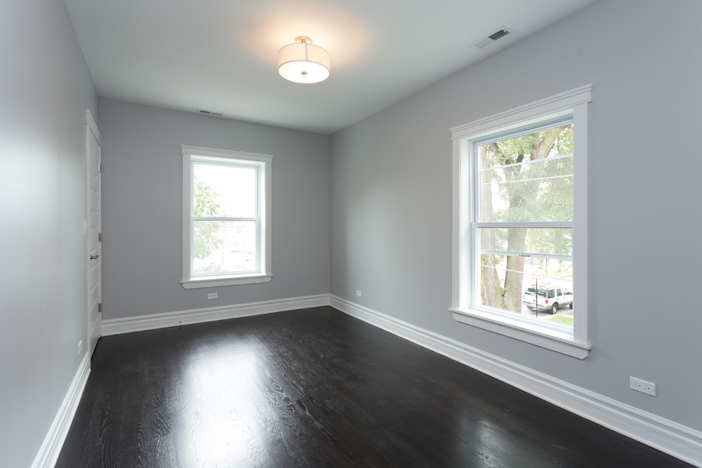 Foto på ett mellanstort funkis sovrum, med grå väggar, mörkt trägolv och brunt golv