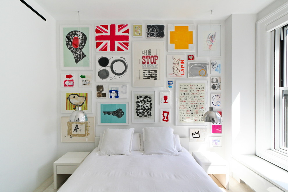 Example of a small danish light wood floor bedroom design in New York with white walls